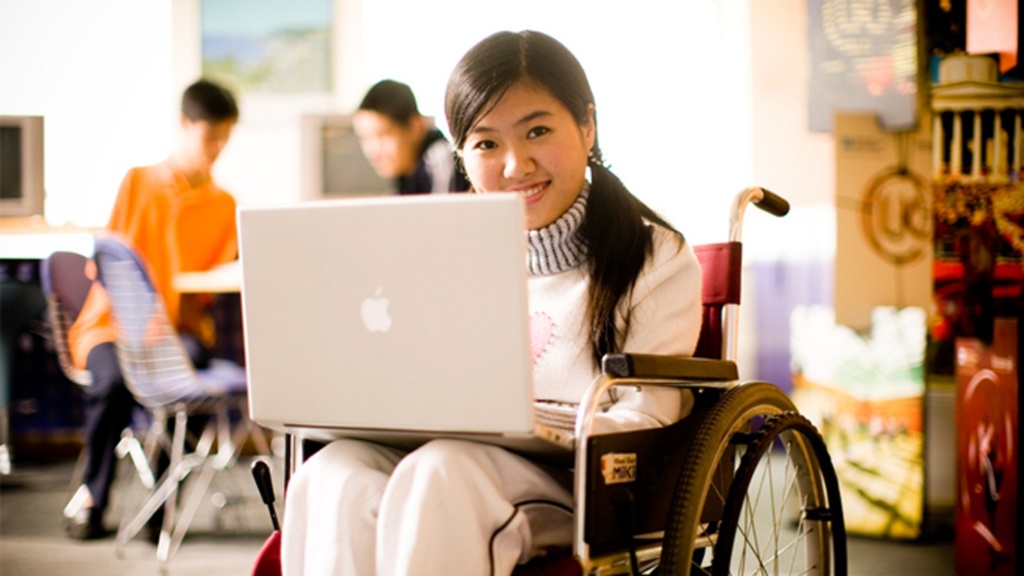 Girl student in a wheelchair using her laptop