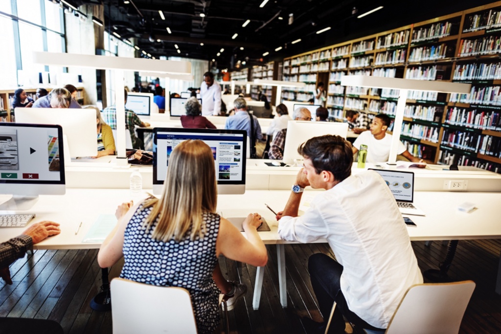 Students working in a library on PC's