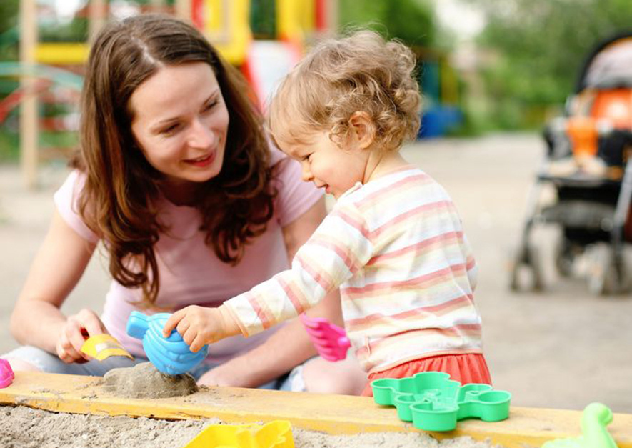 Mother and child playing outside in a park.