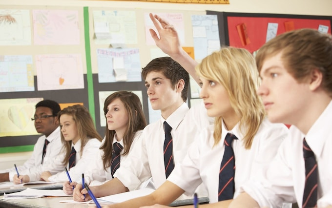 Row of UK secondary school students sitting in class.