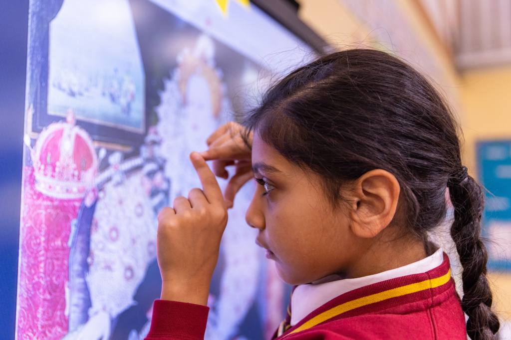 Primary school girl looking at a piece of art on a computer screen.