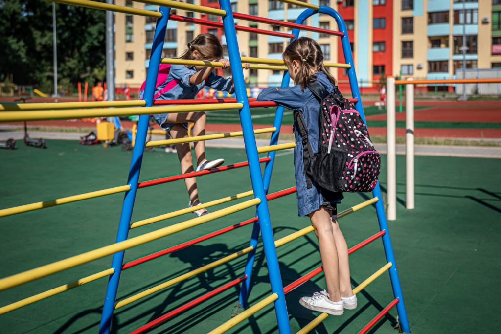 Primary school girl on a playground climbing frame.