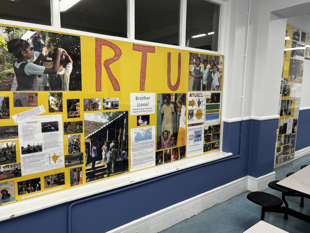 Student or pupil art and work about an international partnership trip decorating a wall in an empty school classroom.